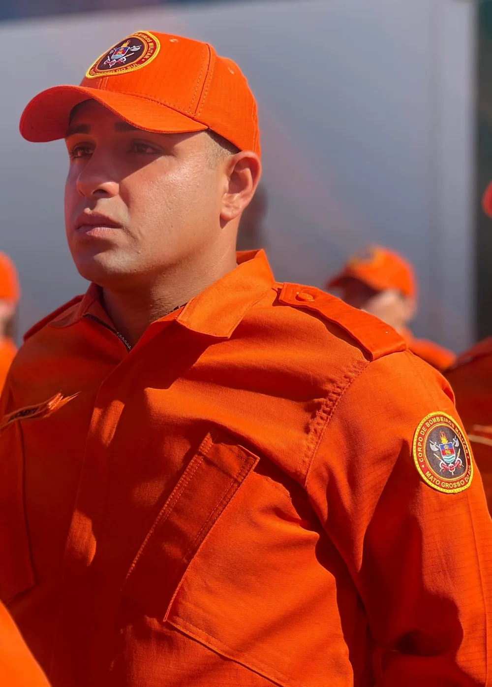Bombeiro militar com uniforme e boné laranja