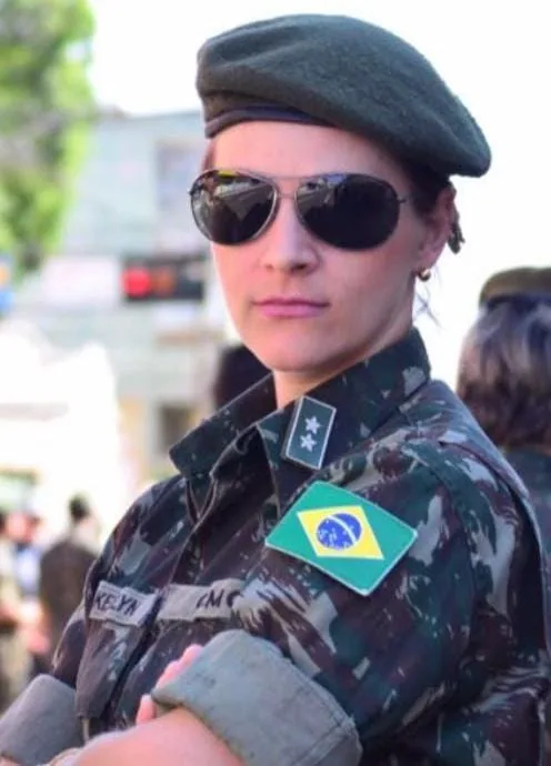 Profissional de boina e uniforme camuflado do Exército, com a bandeira do Brasil no braço